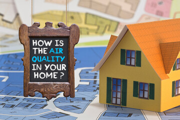 HOW IS THE AIR QUALITY IN YOUR HOME? - concept with home model, wooden sign and text