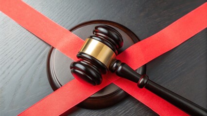 law restriction policy concept. Gavel on a wooden block with red tape across it.