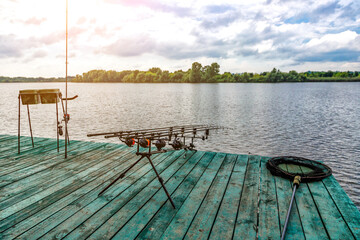 Carpfishing session at the Lake.Carp fishing rods standing on special tripods.Carp Angling scenic...