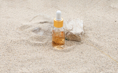 The serum skincare bottle rests effortlessly on the sand, creating a serene and natural aesthetic that embodies effortless beauty.