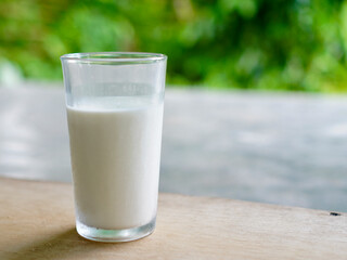 A glass of milk stands on a bokeh background. Fresh milk for healthy life