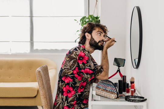 Stylish influencer records a makeup tutorial at home, showcasing his grooming routine and embracing diversity in the lgbtq community. LGBTQ lifestyle concept