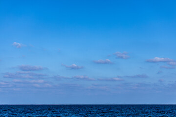 Obraz premium Serene Blue Horizon Over Tranquil Ocean Waters with Soft Clouds in a Clear Sky - A Perfect Peaceful Scene for Nature Lovers and Ocean Enthusiasts Alike
