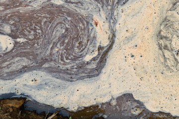 Swirling foam in a waterway during an overcast day