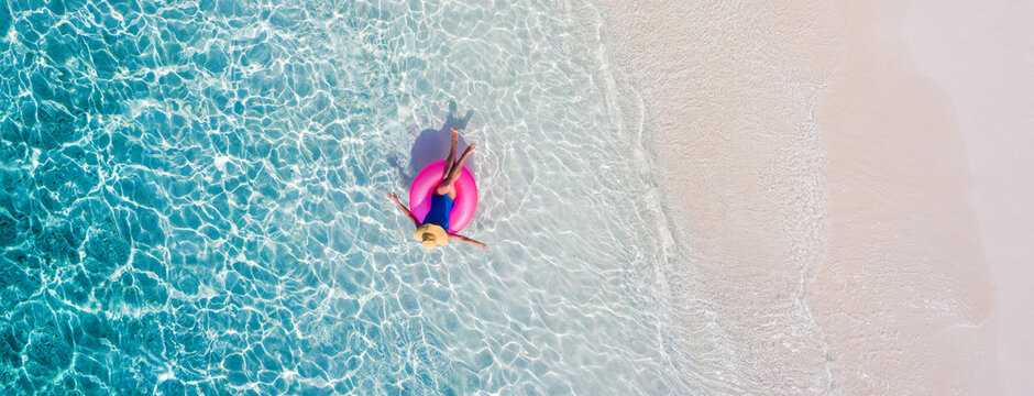 Top above high angle aerial drone view of her she attractive girl rich chic lady floating on rubber ring in clean clear transparent ocean water enjoy joy coastline sunny weather exclusive tour agency