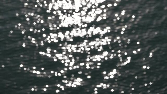Vue en hauteur sur des points lumineux de reflets du soleil sur l'eau avec effet flou d'objectif