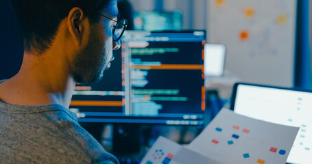 Closeup young adult Asia male freelance typing write prompt AI bot IT app smart program nomad, video game, terminal with coding language, designer, big data center on desktop computer in night office.