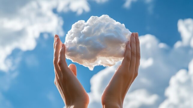 Close-up of hands holding a cloud in the sky, symbolizing the large scale and global nature of cloud computing, with copy space for text or a logo. Stock photo. 