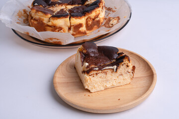 basque burnt cheesecake on wood plate on white background