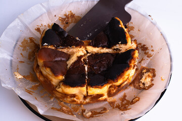 basque burnt cheesecake on wood plate on white background