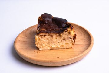 basque burnt cheesecake on wood plate on white background