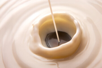 image of milk splashing into a milky surface, showcasing a hypnotic swirl and ripples. Great for dairy industry, nutrition concepts, or artistic food photography with a white background