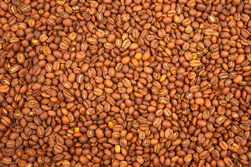 Macro shot of roasted coffee beans, showcasing their deep brown hues and cracked surfaces in a dense arrangement. Ideal for gourmet food and beverage photography.