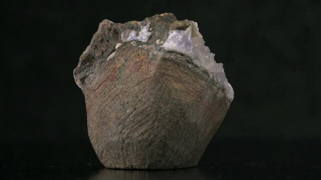 Amethyst (purple quartz) and White Barite crystals on Black Chalcedony, rotating against a black background	
