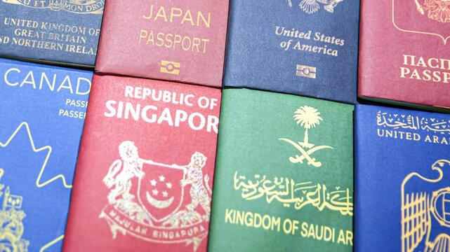 Passports of multiple Nationalities top view 4k footage backdrop. Traveling, document, colorful, nationality, citizenship and visa concept