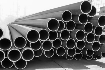 Stack of new, even, long pipelines. Monochrome photo.
