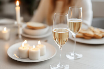 Couple enjoys anniversary celebration with champagne, candles, and a cozy dinner setting