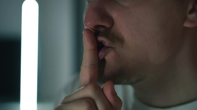 L'homme fait un geste de silence avec ses mains et ses l&egrave;vres.
L'homme exige le silence.
Silence dans la pi&egrave;ce. Personne n'entend.