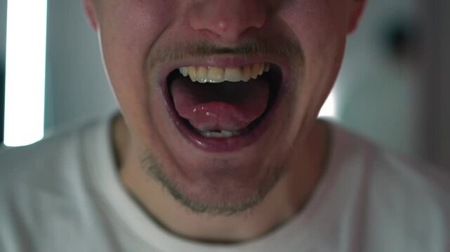 Un hombre saca la lengua delante de la c&aacute;mara.
El hombre sac&oacute; la lengua de la boca.
Expresiones faciales de un hombre.
El hombre se esconde delante de la c&aacute;mara.
Expresiones faciales activas en un hom