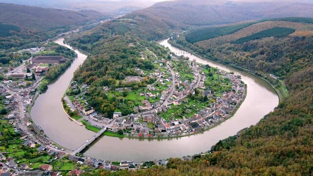 Stunning drone view of Montherm&eacute;, France, capturing the scenic town nestled between lush green hills and the winding Meuse River. A picturesque landscape showcasing nature and charming architecture.