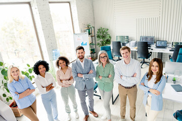 Obraz premium Diverse business team standing together in a modern office environment, multi-age