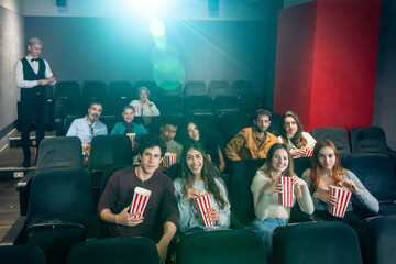 People watching movie and eating popcorn in cinema
