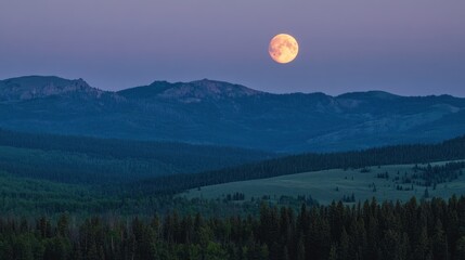 The full moon rises above the rolling hills and dense forests