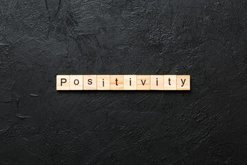 positivity word written on wood block. positivity text on cement table for your desing, concept