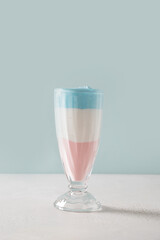 Patriotic layered cocktail for Independence Day in color USA flag on blue background. Food for 4th of July or Memorial Day. Vertical format.
