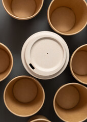 New beige kraft paper cups and reusable bamboo coffee cup on a gray top view, mockup
