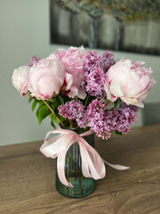 An Elegant Floral Arrangement of Vibrant Peonies and Fragrant Lilacs in a Beautiful Glass Vase