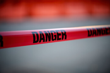 Close-Up View of Red and Black Danger Tape at a Secured Site During Twilight Hours