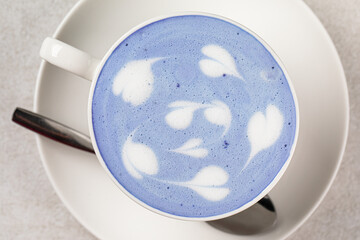 Portion of blue matcha latte in a white cup
