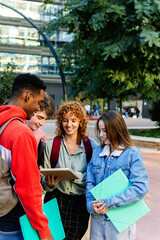 Vertical shot of young group of student friends reviewing college notes before an academic exam at...