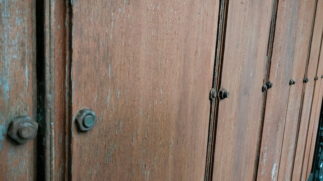 old wooden door with metal handle, An antiquated wooden portal, accompanied by a locking apparatus.