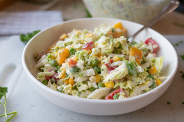 Chinese cabbage salad with peppers, onions, green peas in a delicious dressing. Tasty homemade barbecue salad