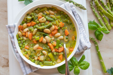 Spring vegetable soup with white beans on a plate fresh and homemade cooked