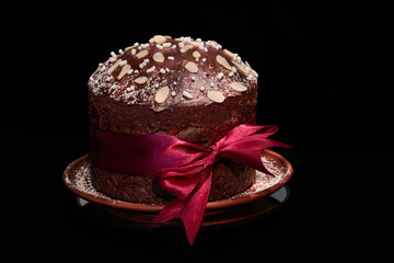 Panettone cake is a traditional Italian dessert for Easter and Christmas. Easter and Christmas pastries: kulich, paska. Chocolate dough. Close-up on black background