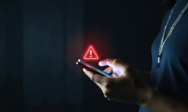 SMS spam, fake text message phishing from scammer concept. System hacked red warning alert, email hack, scam malware spreading virus on message alert virtual on mobile phone screen in person hand