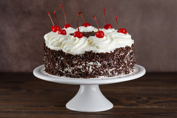Black forest cake, Schwarzwald pie on a brown wooden table. Cake with dark chocolate, whipped cream...
