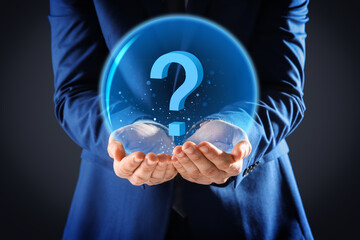 Businessman holding virtual sphere with question mark on dark background, closeup