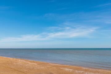 Looking north over the calm blue waters of Lake Michigan along the shoreline beach at Harrington Beach State Park, Belgium, Wisconsin in early March