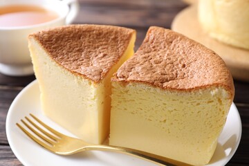 Pieces of tasty Japanese Castella sponge cake, tea and fork on table, closeup