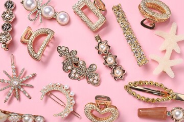 Different hair clips on pink background, flat lay