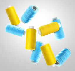 Spools of light blue and yellow sewing threads falling on gradient background