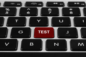 Online test. Laptop keyboard with word on red button, closeup