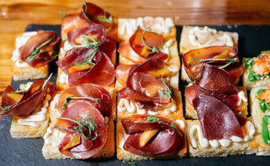Gourmet bruschetta with cured meat and cream on bread. Elegant bruschetta canapés made with...