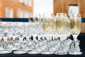 Champagne glasses prepared for outdoor event.