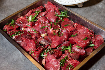 Raw beef chunks marinated with rosemary.