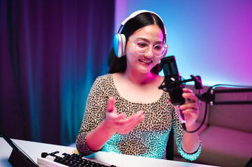 Teenager girl hosts podcast in her room using LED lights, computer, headphones, condenser...